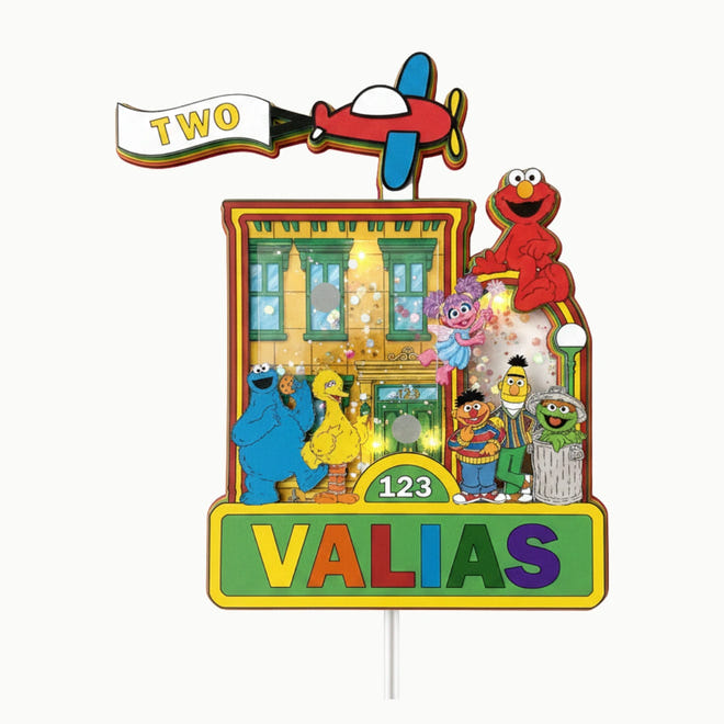 Colorful Sesame Street-themed birthday cake topper with characters and airplane.