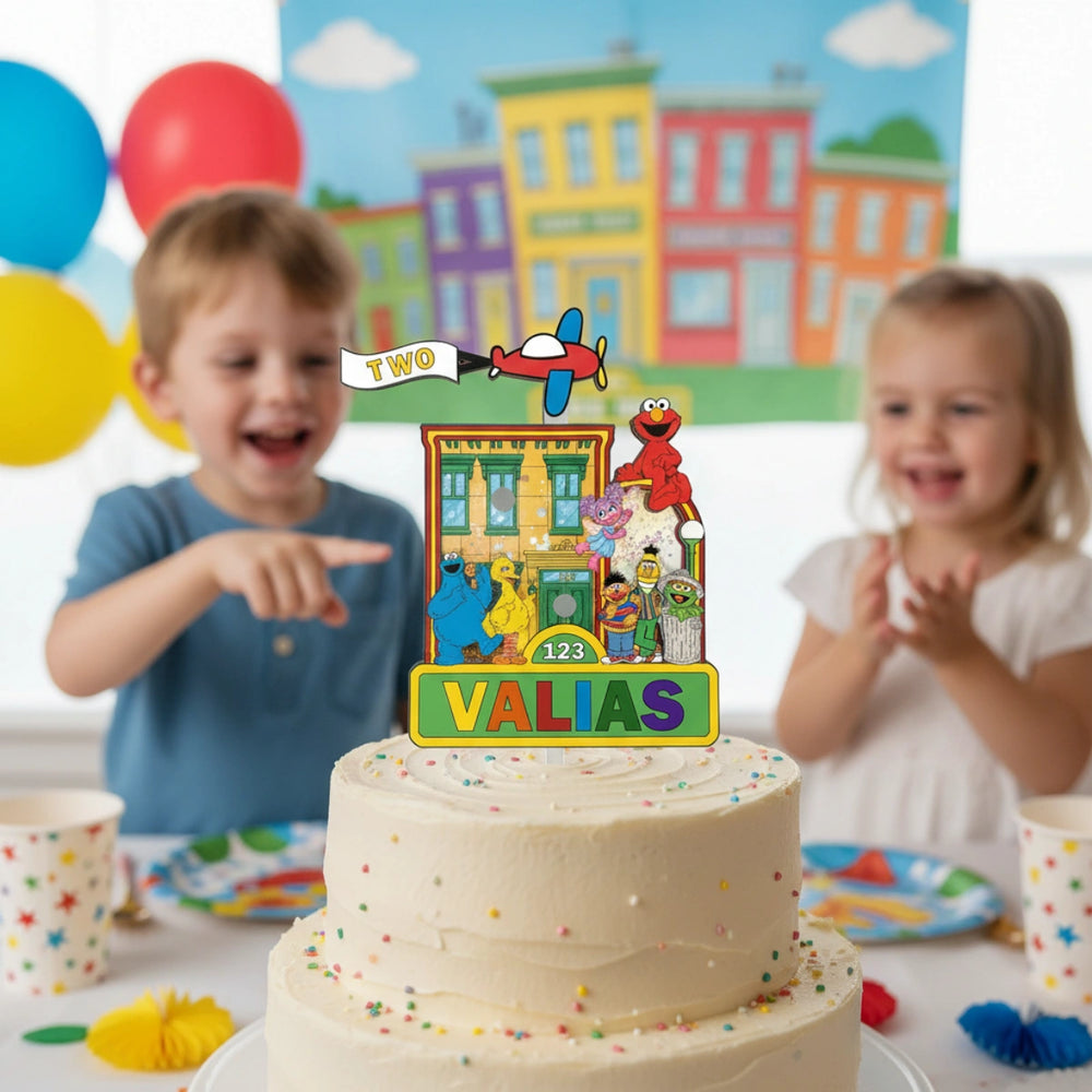 Two children pointing at a birthday cake with Sesame Street-themed topper in a colorful room.