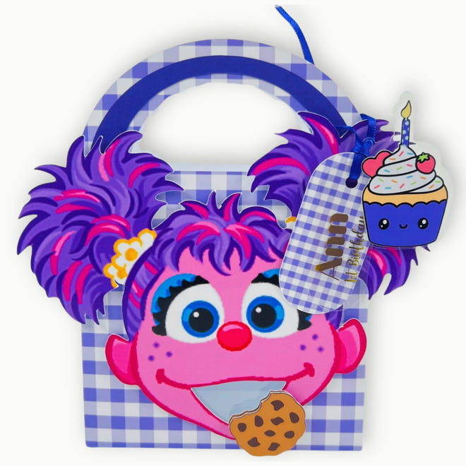 Abby Cadabby Cartoon character with purple hair and a checkered bag, holding a cupcake and cookie.
