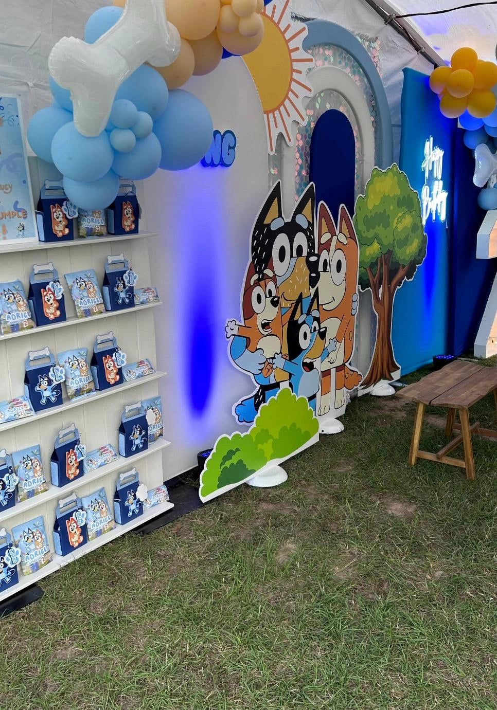 Bluey Children's event setup with cartoon character cutout, balloons, and product display.