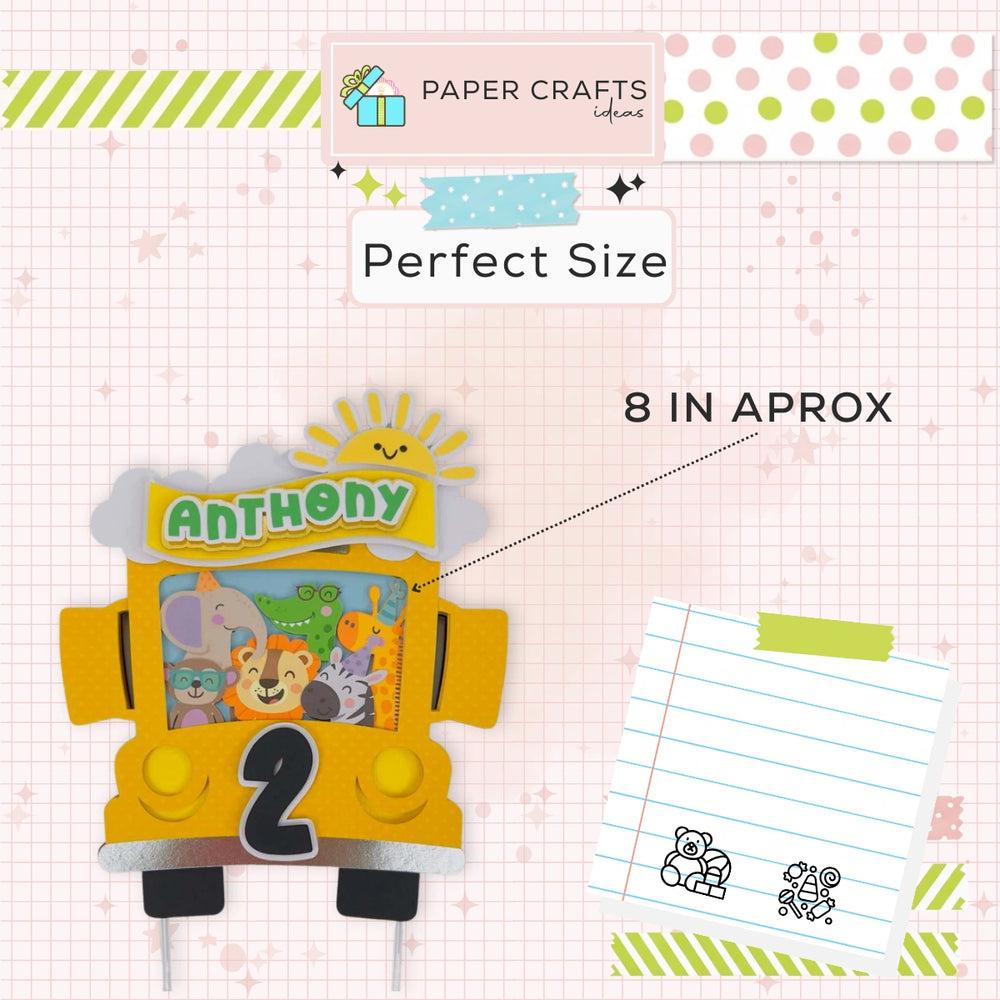 Yellow bus-shaped birthday cake topper with 'Anthony' and number '2', on a checkered background with stationery items.