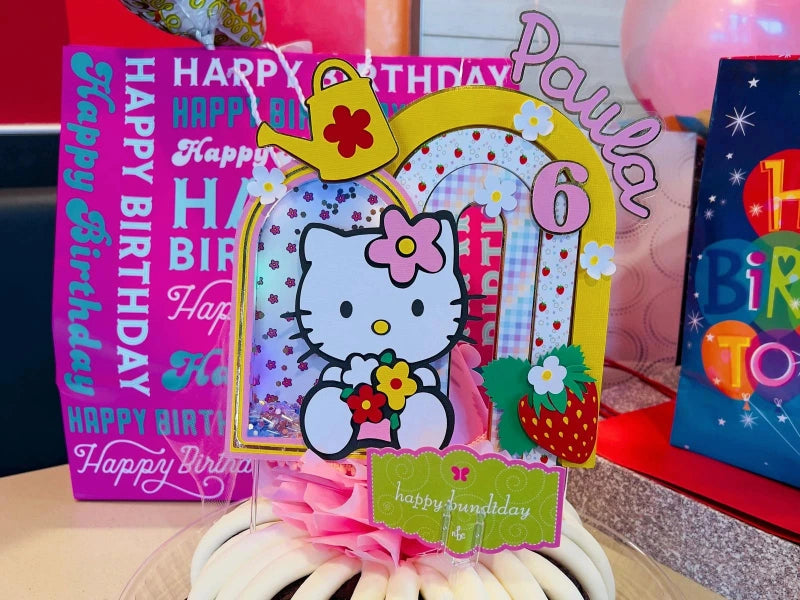 Hello Kitty birthday cake Topper with colorful decorations on a table