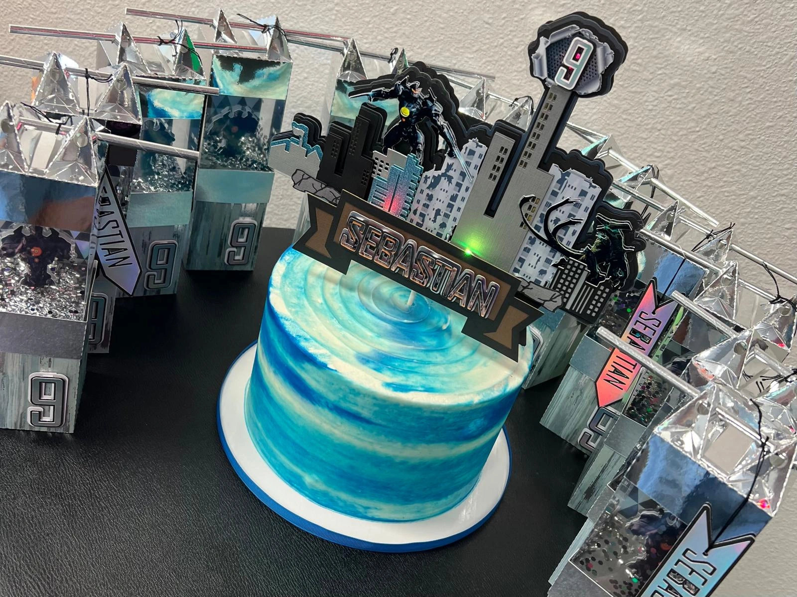 Blue and white cake with Paific Rim Cake Topper with colors lights