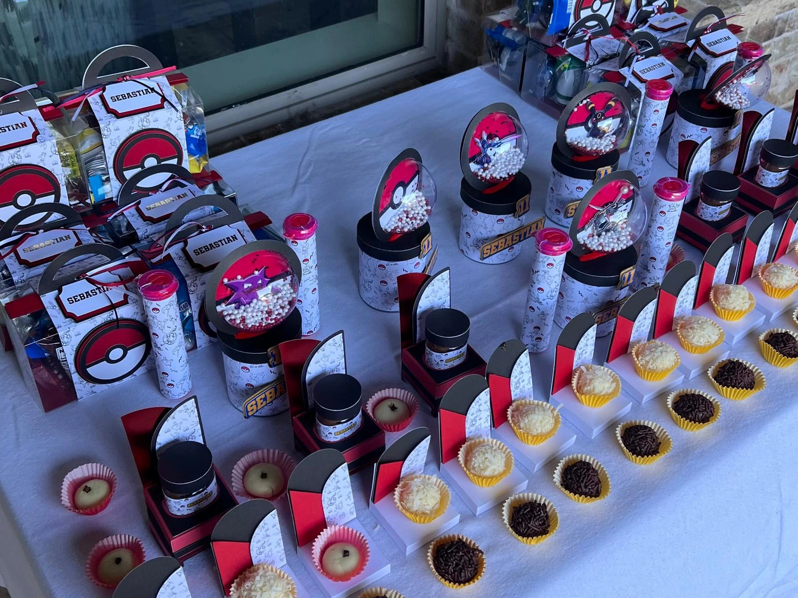 Table with assorted items including containers labeled 'Pokemon' and small cupcakes.