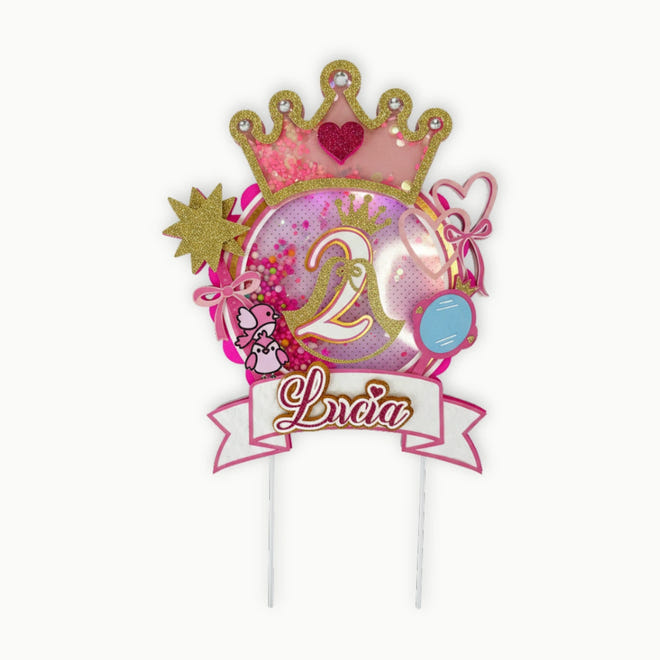 Decorative cake topper with number 2, princess crown, and name 'Lucia' on a white background