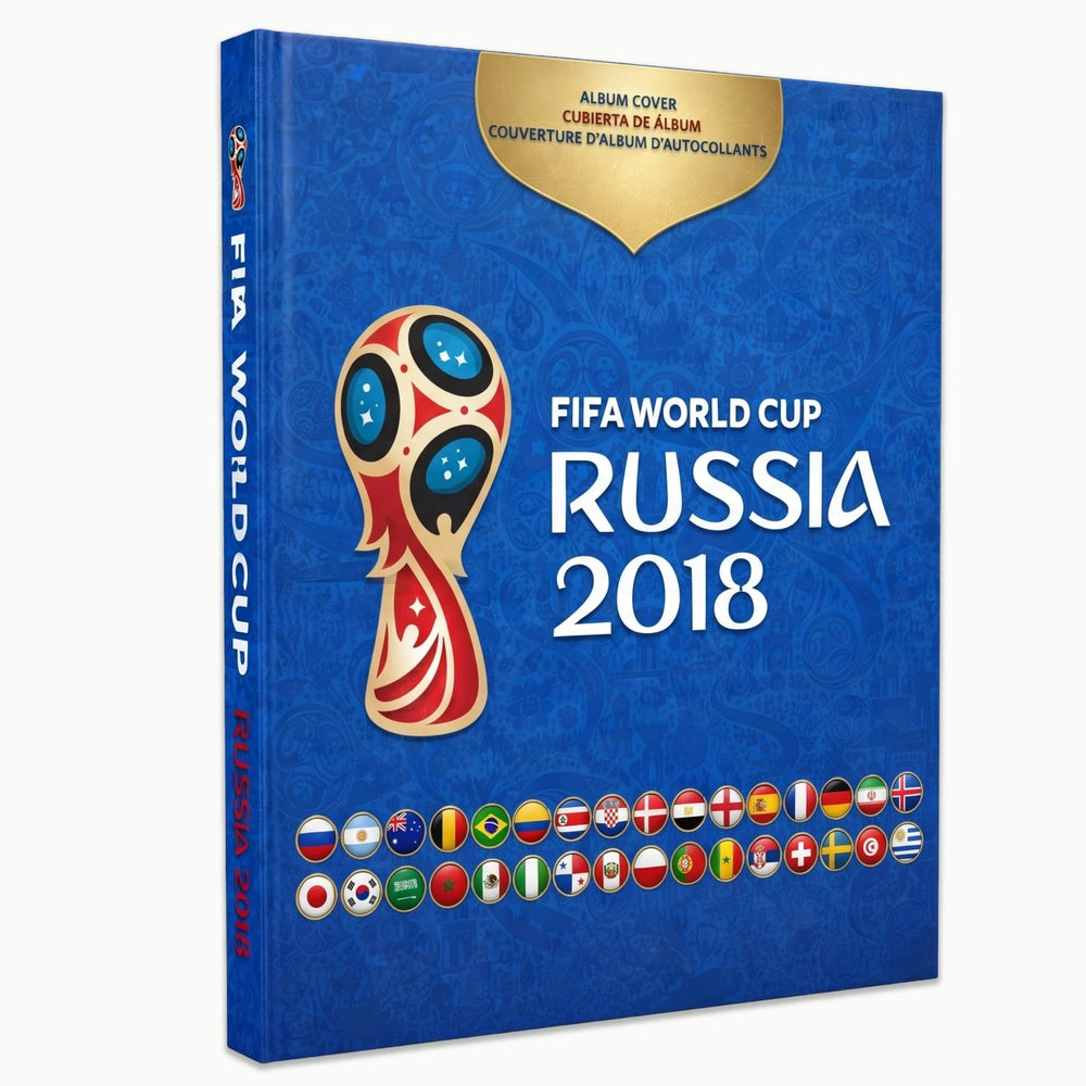 FIFA World Cup Russia 2018 official album cover shown as a 3D book mockup on a light gray background. The cover is predominantly blue with a gold badge at the top, the tournament trophy logo in the center, and the text 'FIFA WORLD CUP RUSSIA 2018' in white.