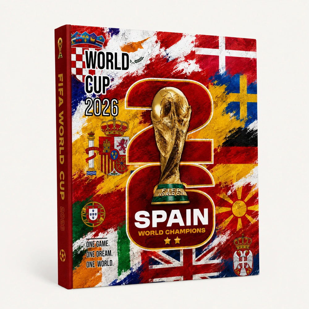 A hardcover FIFA World Cup 2026 Spain commemorative book or album shown at a slight angle on a light gray background. The cover features a vibrant, distressed collage of Spanish national team flags, team colors, the UEFA Champions trophy, the FIFA World Cup trophy, and various national crests, with '2026 SPAIN WORLD CHAMPIONS' printed prominently.